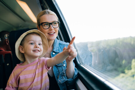 Una mamma con un bambino guardano il paesaggio in treno foto iStock.