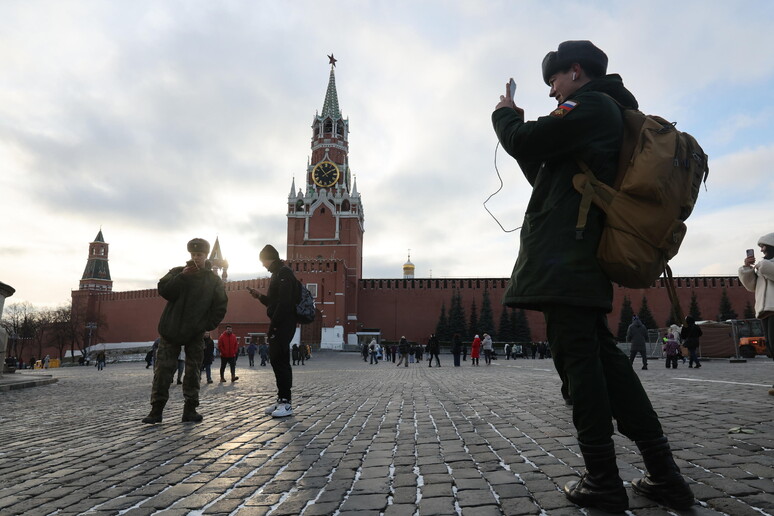 A Russian soldier uses his mobile phone on Red Square outside the Kremlin in Moscow © ANSA/EPA